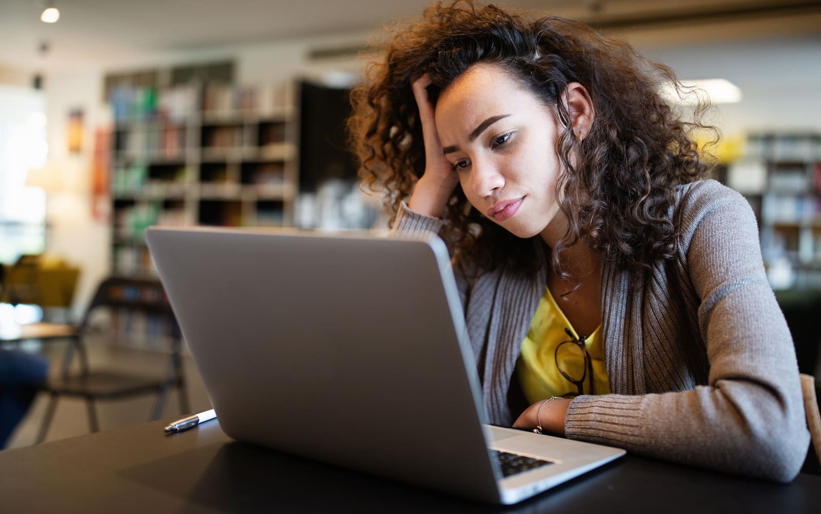 Student studying on a laptop in a university library